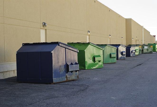 construction workers toss wood scraps into a dumpster in Ellijay, GA